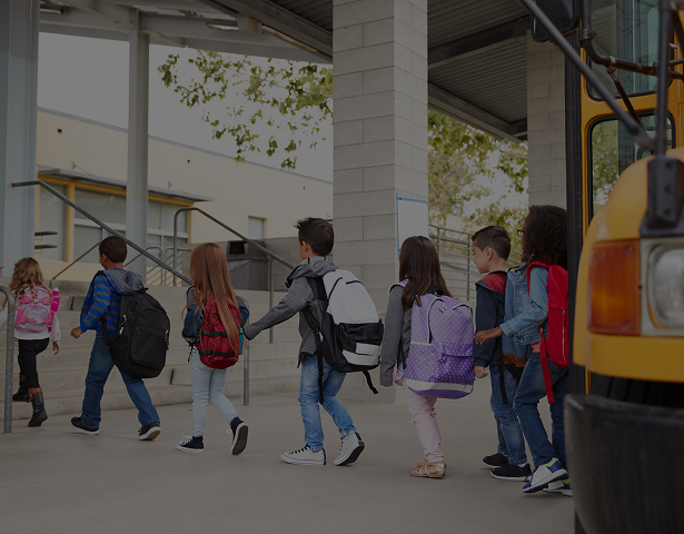Kids with backpacks entering school