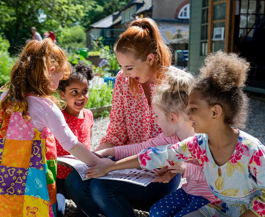 Teacher and children reading outdoors
