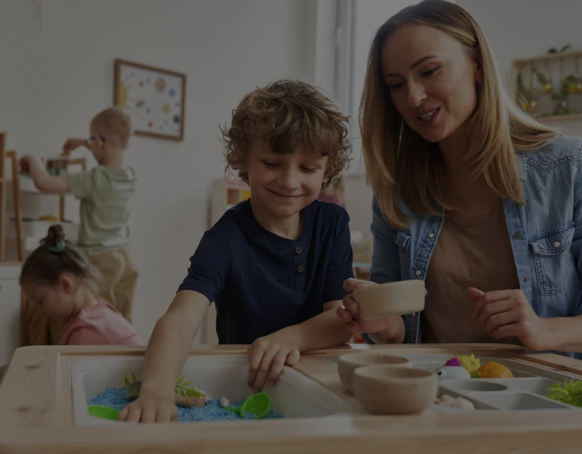 Classroom sensory play with child and teacher