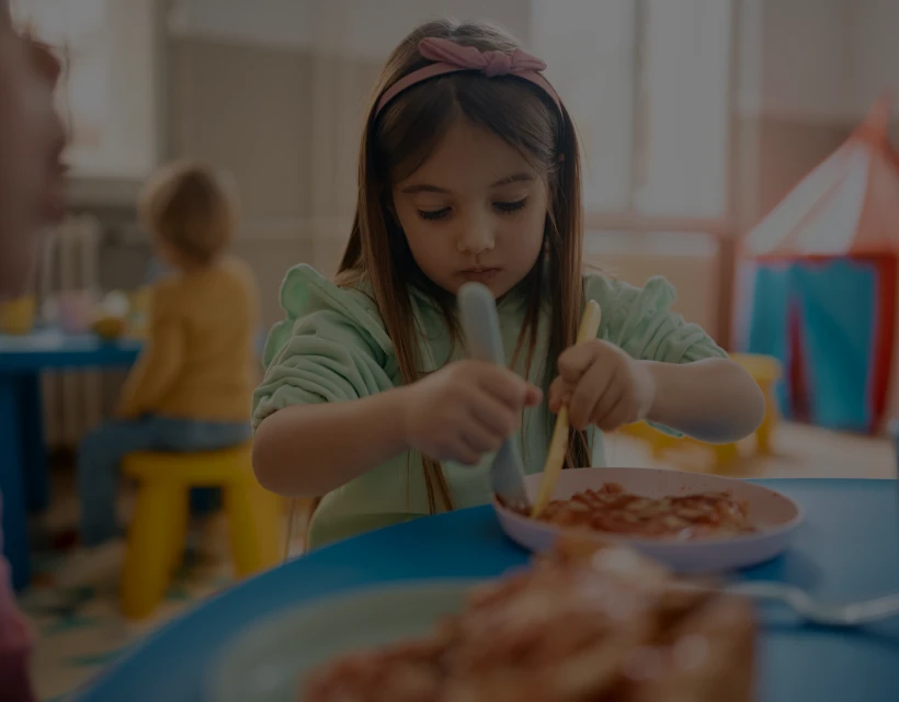 Young girl enjoying pasta lunch